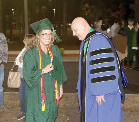 Reba Bridges (left), the student speaker for the Florida Gateway College Fall commencement, shares a laugh with FGC President Lawrence Barrett following the Thursday evening graduation ceremony. (TONY BRITT/Lake City Reporter)