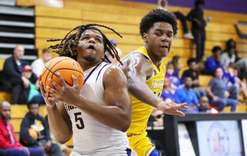 Columbia forward Jalen Gaskins spins past Palatka forward Justin Fells for a layup on Wednesday night. (BRENT KUYKENDALL/Lake City Reporter)