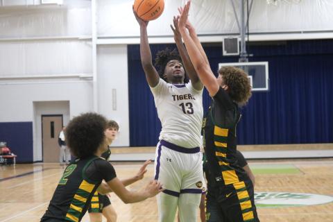 Columbia forward Zavian Douglas shoots over Forest forward Isaac Timmons during the Hitchcock’s Challenge championship on Sunday. (JORDAN KROEGER/Lake City Reporter)