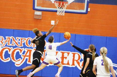 Columbia forward Dariyan Williams goes for a block against Branford guard Cloey Criggall during Monday’s game. (MORGAN MCMULLEN/Lake City Reporter)