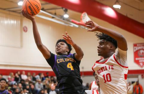 Columbia guard Shaheed White drives past Santa Fe forward Kewan Hall for a layup on Friday night. (BRENT KUYKENDALL/Lake City Reporter)