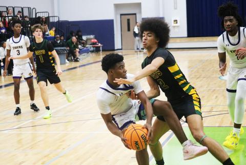 Columbia guard Murkail Cray is fouled by Forest forward Trey Chisolm during the Hitchcock's Challenge championship on Dec. 29. (JORDAN KROEGER/Lake City Reporter)
