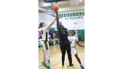 Columbia forward Zavian Douglas slips past Suwannee forward Bryson Parlato (23) and guard MJ Rossin (5) for a layup on Friday night. (PAUL BUCHANAN/Lake City Reporter)