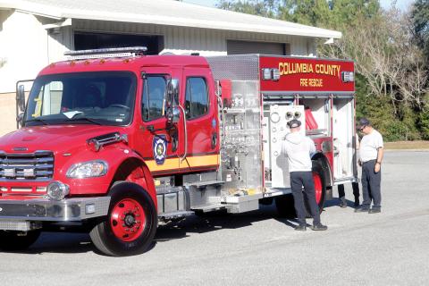 Columbia County Fire Rescue driver/engineer Lucas Harrell (from left) adds firefighting equipment to a new department truck as Columbia County Fire Rescue Battalion Chief Arness Thomas overlooks the operation. Columbia County Fire Rescue could have three new trucks on the department’s front lines by the end of April. (TONY BRITT/Lake City Reporter)