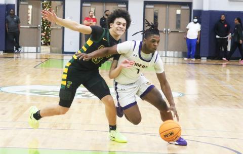 Columbia guard Zamarion Jones dribbles past Forest guard Elijah Leon during the Hitchcock’s Challenge championship on Dec. 29 at Legacy Park in Alachua. (JORDAN KROEGER/Lake City Reporter)