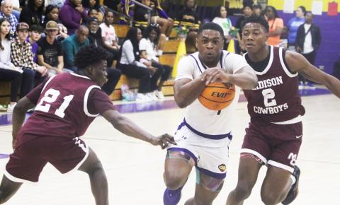 Columbia guard Zamarion Jones drive to the basket between Madison County’s Sean Williams (21) and Jhy Smith (2) on Friday night. (MORGAN MCMULLEN/Lake City Reporter)