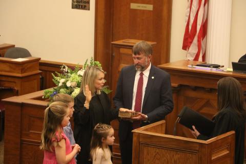 Kathryn ‘Katy’ Land is sworn in as a Third Judicial Circuit judge Friday by Judge Melissa Olin as her husband, Travis, holds the Bible. They are joined by their children Jack, Dylan and Tyler. (MORGAN MCMULLEN/Lake City Reporter)