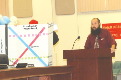 Michael Reynolds gives a presentation to the Columbia County School Board during Tuesday’s meeting on supply and demand of teacher jobs. (TONY BRITT/Lake City Reporter)
