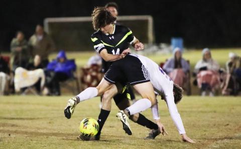 Columbia’s Bobby Shotwell fends off a Gainesville defender while trying to maintain possession of the ball on Jan. 10. (BRENT KUYKENDALL/Lake City Reporter)