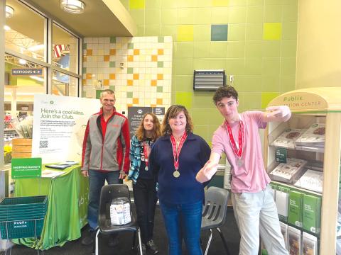 Jeff Wegner (from left), a Special Olympic Athletes Coach at Lake City Christian Academy, stands with athletes Jersey, Donna and Wyatt, after a fundraising session in the Lake City Publix super market. (COURTESY)