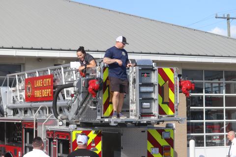 Lake City firefighter Christina Munro (left) flashes a big grin as she and Dustin Alford look over the fire department’s newest engine on Thursday. (TONY BRITT/Lake City Reporter)