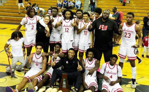 The Fort White boys basketball team celebrates with the District 6-R trophy after defeating Trenton 45-44 on Friday night. (COURTESY)