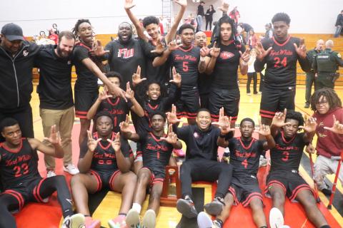 Fort White’s boys basketball players and coaches hold up their Ls after earning a trip to Lakeland with a 54-51 win over Hilliard in the Region 3-R championship on Tuesday. (MORGAN MCMULLEN/Lake City Reporter)