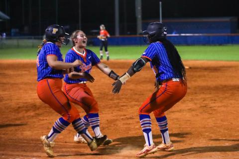 Branford first baseman Victoria Swain (left) and outfielder Ellie Frierson (middle) embrace pitcher Mallory Blue after Blue's walk-off infield single lifted the Buccaneers to a 6-5 win over Trenton on Tuesday. (BRENT KUYKENDALL/Lake City Reporter)