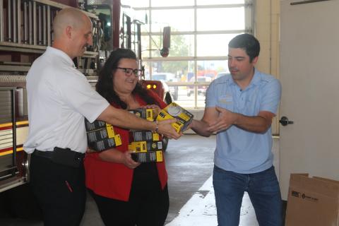 Joseph Peurrung, the owner of Security Safe (right), and Chelsea Flores, owner of Chelsea Flores State Farm Insurance, donated 24 smoke detectors to the Lake City Fire Department this week. Assistant Fire Chief Ret Tompkins accepted their donation. (TONY BRITT/Lake City Reporter)