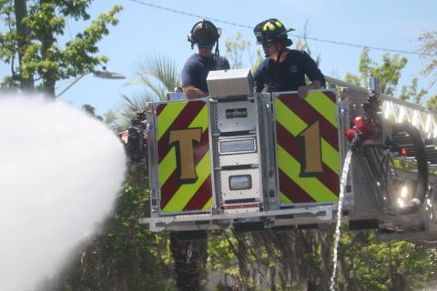 Lake City firefighters Hunter Anderson (from left) and Elliot Redish use two different hoses that will be used to douse blazes as they trained in the department’s newest fire truck. (TONY BRITT/Lake City Reporter)