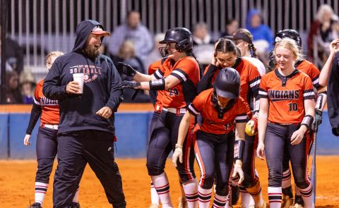 Fort White pitcher Kadence Compton celebrates with teammates and assistant coach Josh Robinson after hitting a home run against Branford on March 10. (JACK HOWDESHELL/Lake City Reporter)