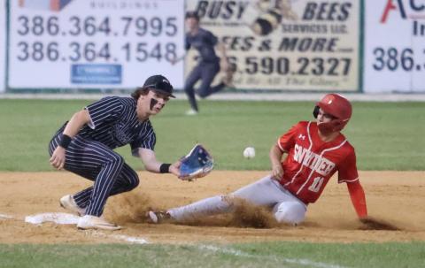 Bishop Snyder center fielder Tristan Silver slides to third base as Suwannee third baseman Jace Moran eyes a throw on Wednesday night. (PAUL BUCHANAN/Lake City Reporter)