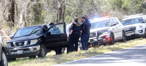 Lake City police officers talk after a black Nissan Frontier pickup was pulled over Monday afternoon on County Road 252. The driver of the pickup, Joe Markham, was arrested for pulling a firearm during a road rage incident moments before on S. Main Boulevard. (TONY BRITT/Lake City Reporter)