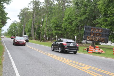 Cars pass a sign on Bascom Norris Drive on Monday warning them of road construction starting on the road, the busiest road maintained by Columbia County. (TONY BRITT/Lake City Reporter)