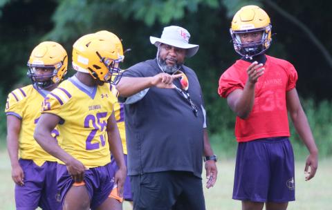Columbia runnings back coach Quinton Callum (middle) speaks with running back Jerome Horne (left) and quarterback Xavier Collins during Monday’s practice. (JORDAN KROEGER/Lake City Reporter)