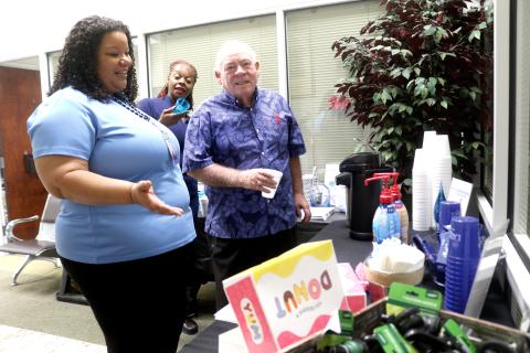 Chanel Neff (clockwise from left), a City of Lake City Customer Service Department employee, encourages Tequela Donaldson and Carroll Lee to get some donuts and coffee during the city’s customer service appreciation festivities last Friday. (TONY BRITT/Lake City Reporter)