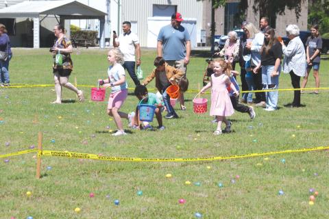 Kids race to gather Easter eggs during the Easter Extravaganza put on by The Canopy at Harper Lake on Saturday afternoon. (TONY BRITT/Lake City Reporter)