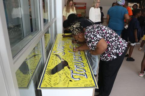 Tanika Dorsey, who has a pair of twins set to attend Niblack as fifth graders next school year, autographs a Niblack sign in the cafeteria of the new Niblack Elementary building. (MORGAN MCMULLEN/Lake City Reporter)