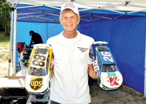 Richard Carroll, the owner of the Suwannee Valley RC Speedway, shows off a pair of the remote control cars that race at the small oval track in Live Oak once a month. (ROB WOLFE/Lake City Reporter)