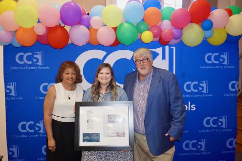Summers Elementary VPK paraprofessional Kelsie Rodriguez (center) was honored by Columbia School Board member Narrie Smith (left) and Superintendent Keith Couey during Tuesday’s school board meeting. (COURTESY)