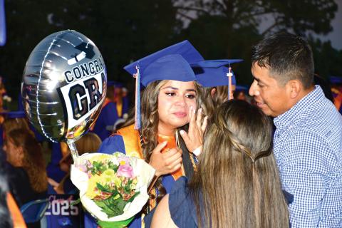 Tears are wiped away from Branford graduate Ashley Morales’ face during an emotional moment with loved ones Friday night during Branford’s commencement. BHS seniors take the class flower — a white rose this year — to parents and family members during the ceremony. (ROB WOLFE/Lake City Reporter)