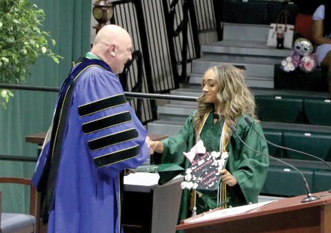 Sakiya Merriex receives her associate in arts degree from Florida Gateway College President Larry Barrett during commencement Thursday at the Howard Center. (MORGAN MCMULLEN/Lake City Reporter)