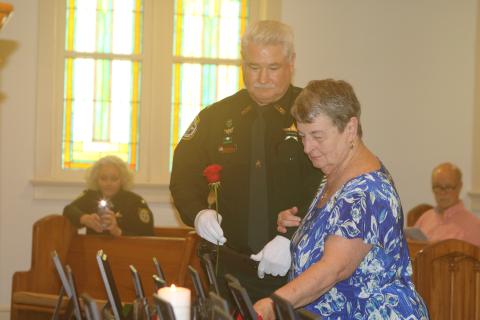 Pat Davis places a rose to honor her son, late Columbia County Sheriff’s Deputy Jeff Davis, during last year’s Public Safety Memorial ceremony. (FILE)