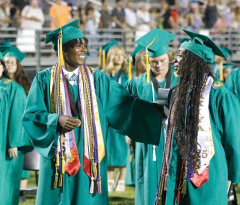 Suwannee graduates Joseph Alicea (left) and Jakiya Washington sing the alma mater during Saturday night’s commencement at Langford Stadium. (JAMIE WACHTER/Lake City Reporter)