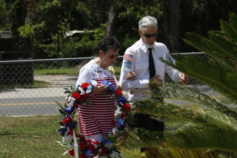 Rosemary Ivie with the Live Oak Garden Club prepares to place a wreath at the veterans memorial during the Memorial Day observance Monday at the Live Oak Cemetery. (JAMIE WACHTER/Lake City Reporter)