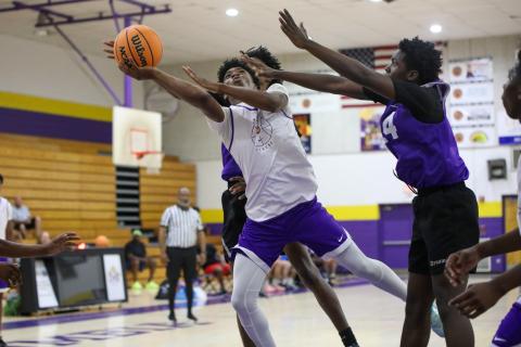 Columbia’s Murkail Cray splits a pair of Gainesville defenders on a layup attempt Thursday night during a summer league game. (BRENT KUYKENDALL/Lake City Reporter)
