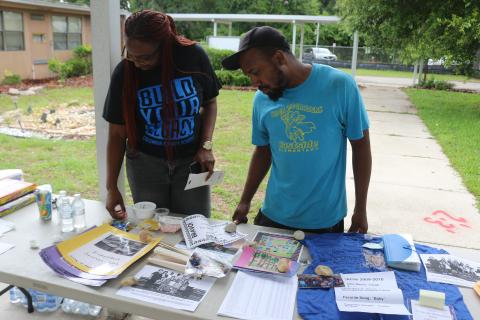 Shanetha Anthony (from left) and Damarrick Hendon, look through Eastside Elementary School items that were pulled from a time capsule to the school’s final walkthrough on Thursday afternoon. (TONY BRITT/Lake City Reporter)