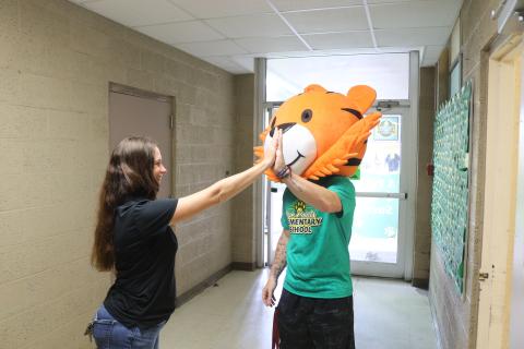 Five Points Elementary Principal Brandi Keen high fives teacher William Sheldon, who is wearing a tiger mascot head, during the school’s final walkthrough on Monday. (TONY BRITT/Lake City Reporter)