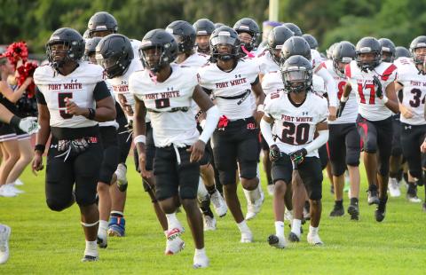 Fort White’s football team takes the field for its spring game against Columbia on May 17. (BRENT KUYKENDALL/Lake City Reporter)