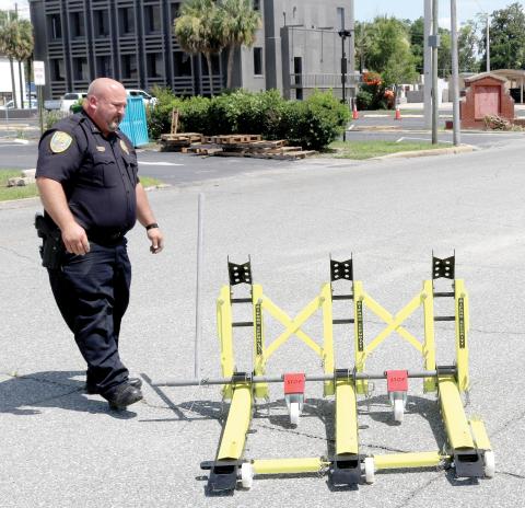 Lt. Garrett Register looks at a modular vehicle barrier on Wednesday. The Lake City Police Department used federal grant funding to obtain the barriers as a way to block off roads during events to protect pedestrians. They will be used for the first time Friday. (TONY BRITT/Lake City Reporter)