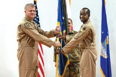 U.S. Air Force Brig. Gen. Travis Edwards, right, 379th Air Expeditionary Wing incoming commander, receives the 379th AEW guidon from Maj. Gen. David Shoemaker, 9th Air Force (Air Forces Central) deputy commander, during the 379th AEW Change of Command Ceremony within the U.S. Central Command area of responsibility, June 9, 2025. (Staff Sgt. Sean Moriarty/U.S. Air Force)