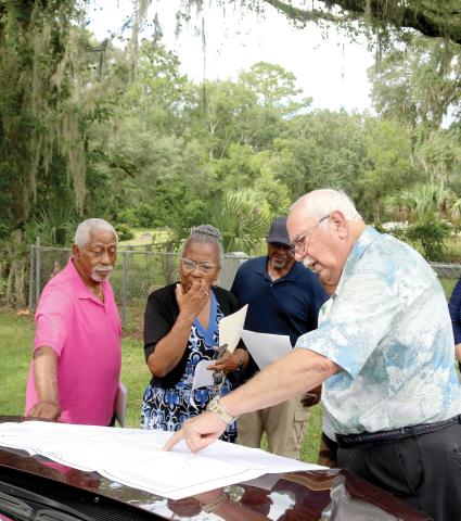 Raymond Brady (from left), Patricia Brady and Terry Harrell look on as Chuck Denmark, a trustee of Bethel Community Cemetery, uses a map to show property lines and easement for the Brady-Jones Bethel Community Cemetery. Bethel Community Cemetery trustees recently gave Brady-Jones Bethel Community Cemetery trustees a deed to the cemetery which is adjacent to Bethel Community Cemetery. (TONY BRITT/Lake City Reporter)