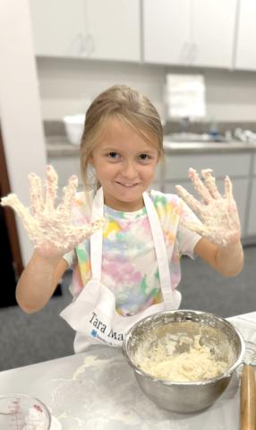 Tara Markham shows hands full of dough after mixing her first sourdough loaf. (COURTESY)