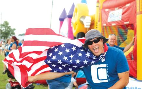 Earnest Burch waved down festival-goers with his Old Glory cape at the 2019 Independence Day event at the Columbia County Fairgrounds. (FILE)