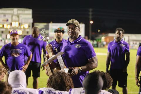 Columbia coach Brian Allen holds the Old Oaken Bucket trophy after the Tigers’ 42-6 rout of Suwannee at Langford Stadium on Friday night. (BRENT KUYKENDALL/Lake City Reporter)