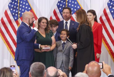 Jay Collins, a former Green Beret and decorated veteran, left, is sworn in as Florida’s new lieutenant governor by Florida Supreme Court Justice Jamie Grosshans on Tuesday in Tampa. He is joined by his wife, Layla, and their sons, Gabe and Colt. At right, Florida Gov. Ron DeSantis stands with his wife, Casey DeSantis. (DOUGLAS CLIFFORD/Tampa Bay Times/TNS)