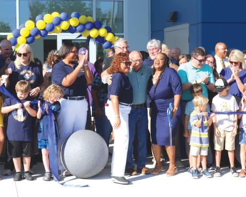 School Board members Narrie Smith (center) and Keith Hudson share a hug with Niblack Elementary School principal Makeba Murphy after she cut the ribbon for the new school on Thursday morning. (TONY BRITT/Lake City Reporter)