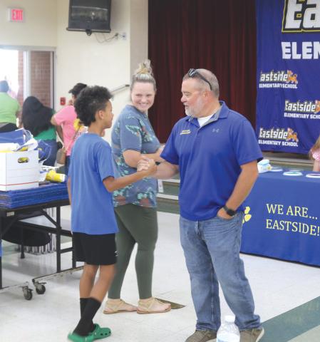 Roger Little (right), Eastside Elementary School principal, greets parents and students as they visit the temporary cafeteria on Thursday during a school Sneak Peak session. More than 100 people visited the school during the session. (TONY BRITT/Lake City Reporter)