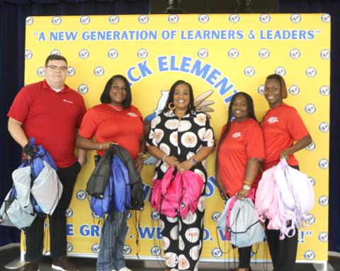 Alexander Zadai (from left), Deanna Lumpkin, Makeba Murphy, Sonical Mitchell and Twylah Queen hold backpacks that Core Civic donated to Niblack Elementary School on Wednesday morning. Core Civic provided roughly 50 backpacks and other school supplies to three local elementary schools. (TONY BRITT/Lake City Reporter)