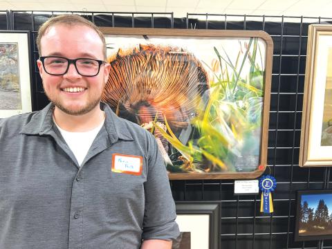Kevin Paulk stands in front of his winning photograph, ‘With an Edge & Charm,’ during Saturday’s photo contest reception hosted at the Gateway Art Gallery. Paulk won a $125 cash prize in the second contest put on by the Branford Camera Club. (COURTESY)